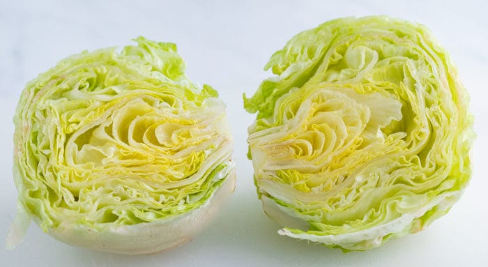 a head of iceberg lettuce cut in half.