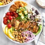 Greek Chicken Bowls with Tomatoes, Cucumbers, Chickpeas, Olives, Feta, Homemade Dressing, and more.