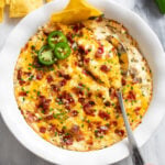 Jalapeno Popper Dip in a white baking dish with sliced jalapenos on top.