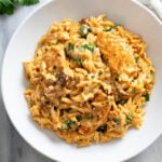 Marry Me Chicken Orzo in a creamy tomato sauce with sun-dried tomatoes and spinach in a white bowl.